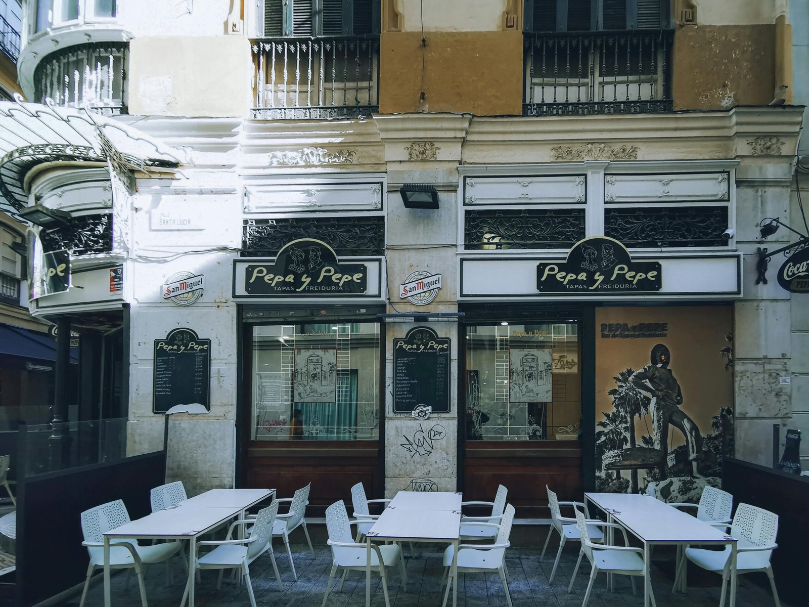Quaint outdoor dining area at 'Pepa y Pepe' tapas bar in urban setting.